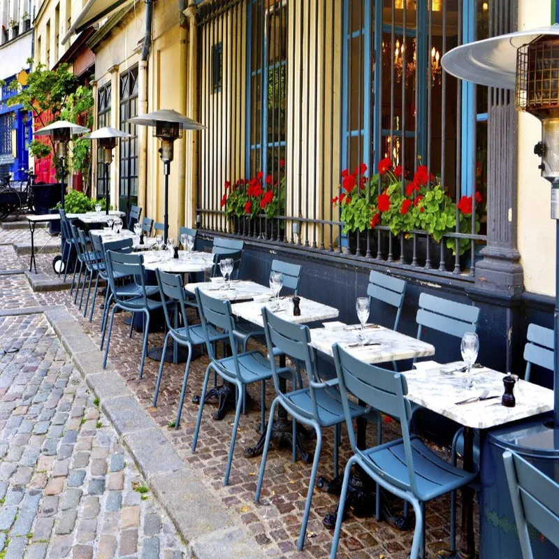 Café tables set along a sunny cobblestone street