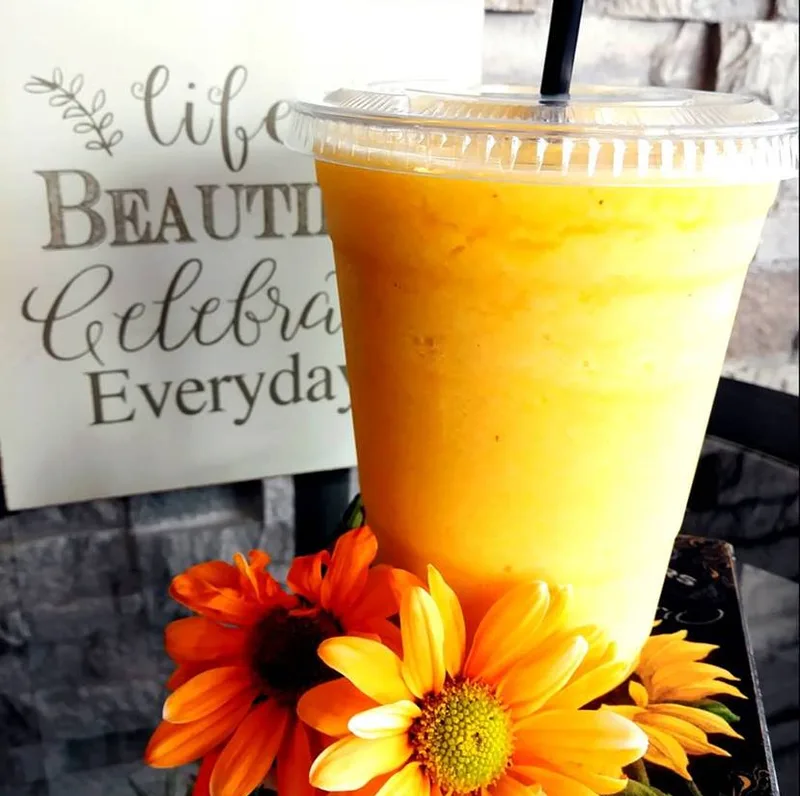 Fresh golden smoothie with orange flowers